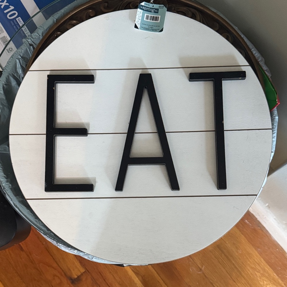Round White Wall Sign with Black 'EAT' Letters